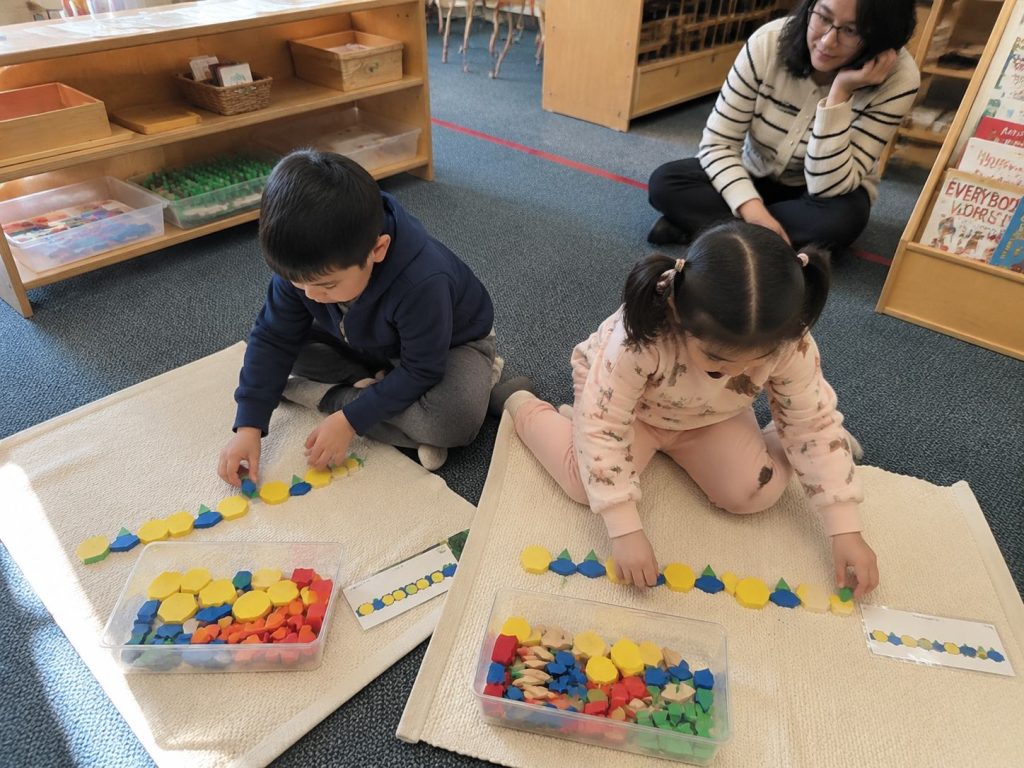 Kindergarten students working independently with pattern-based learning toys during classroom activity